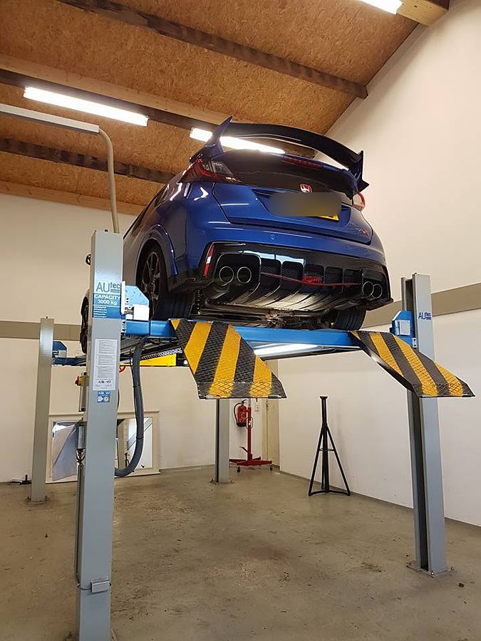 Een blauwe Civic Type R op de brug, onderkant en uitlaat vrij